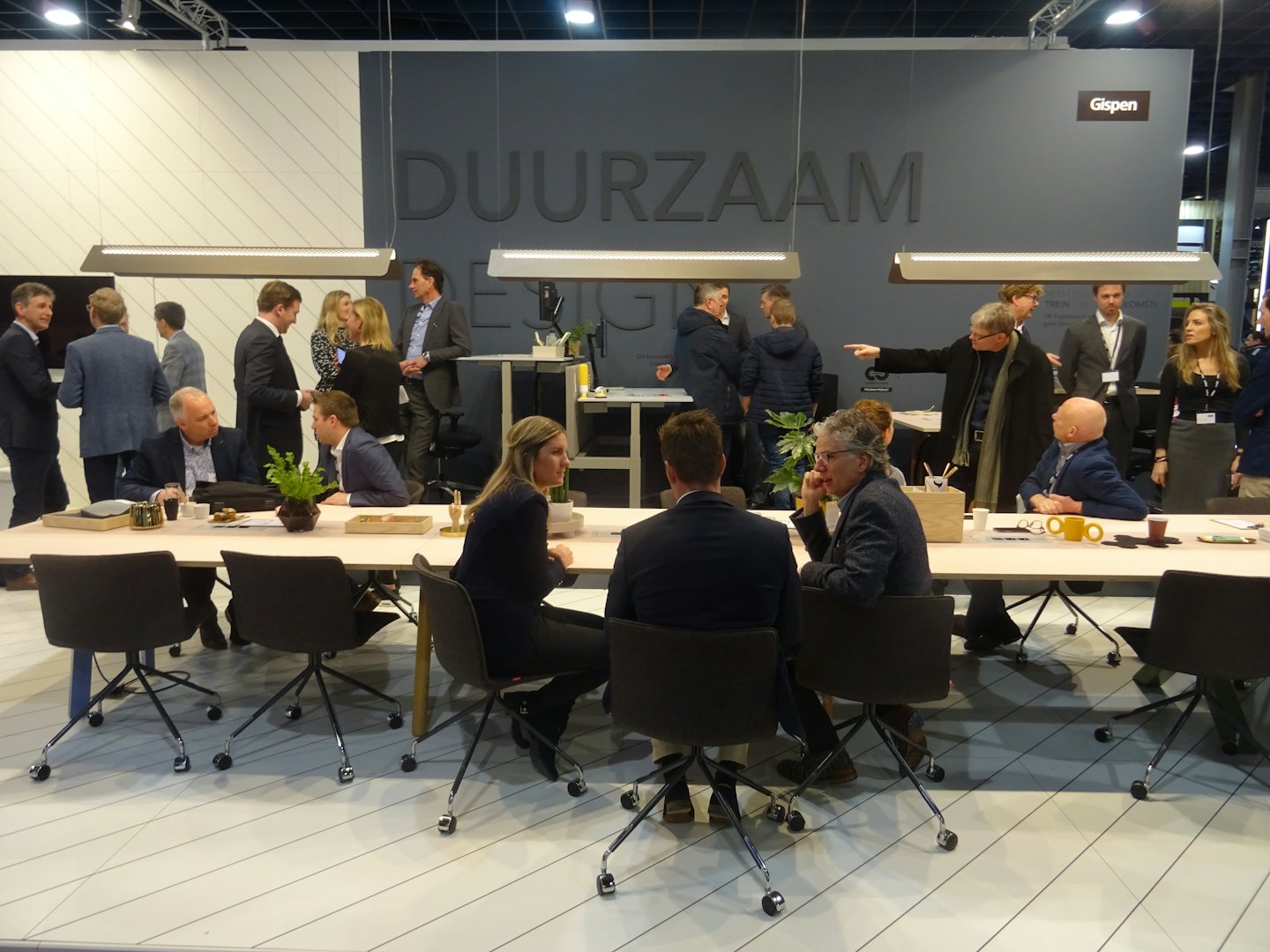 Profesionales haciendo networking en una mesa en un espacio de eventos moderno.