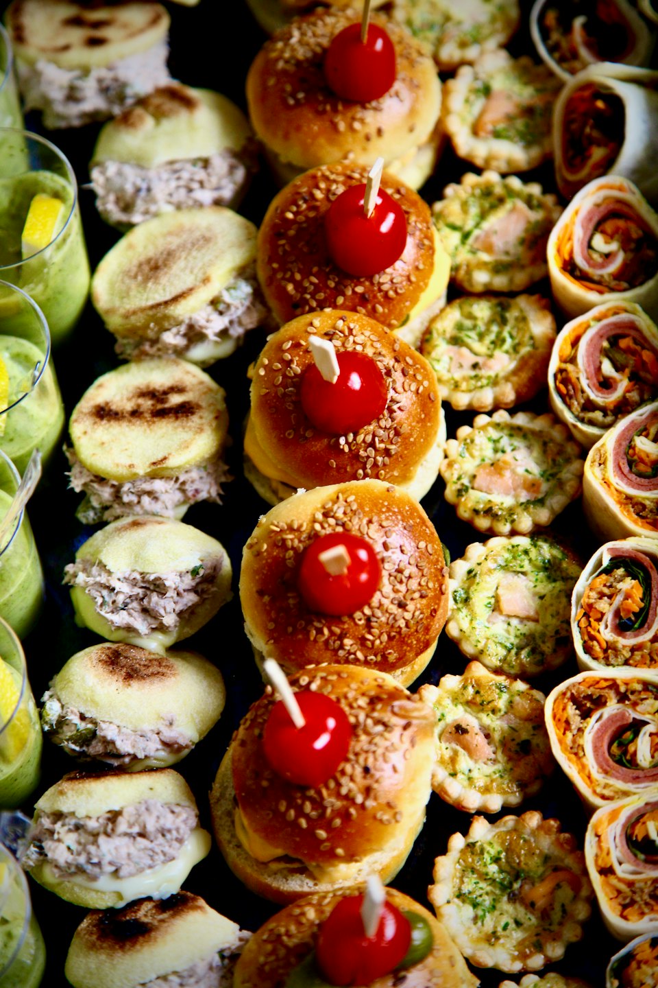 Aperitivos gourmet y batidos verdes dispuestos para un evento.