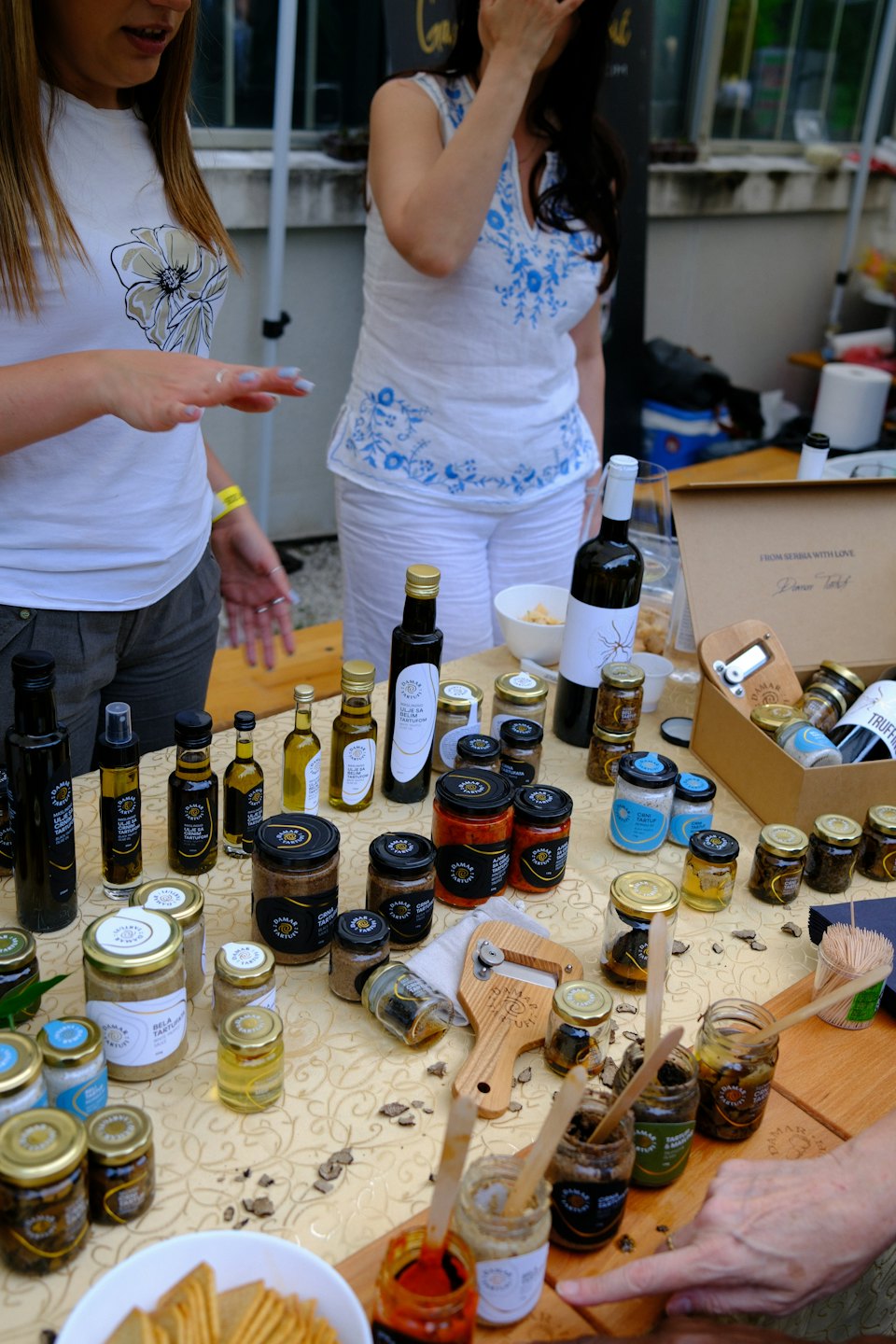 Vendedores ofrecen productos de trufa gourmet en un puesto de mercado al aire libre.